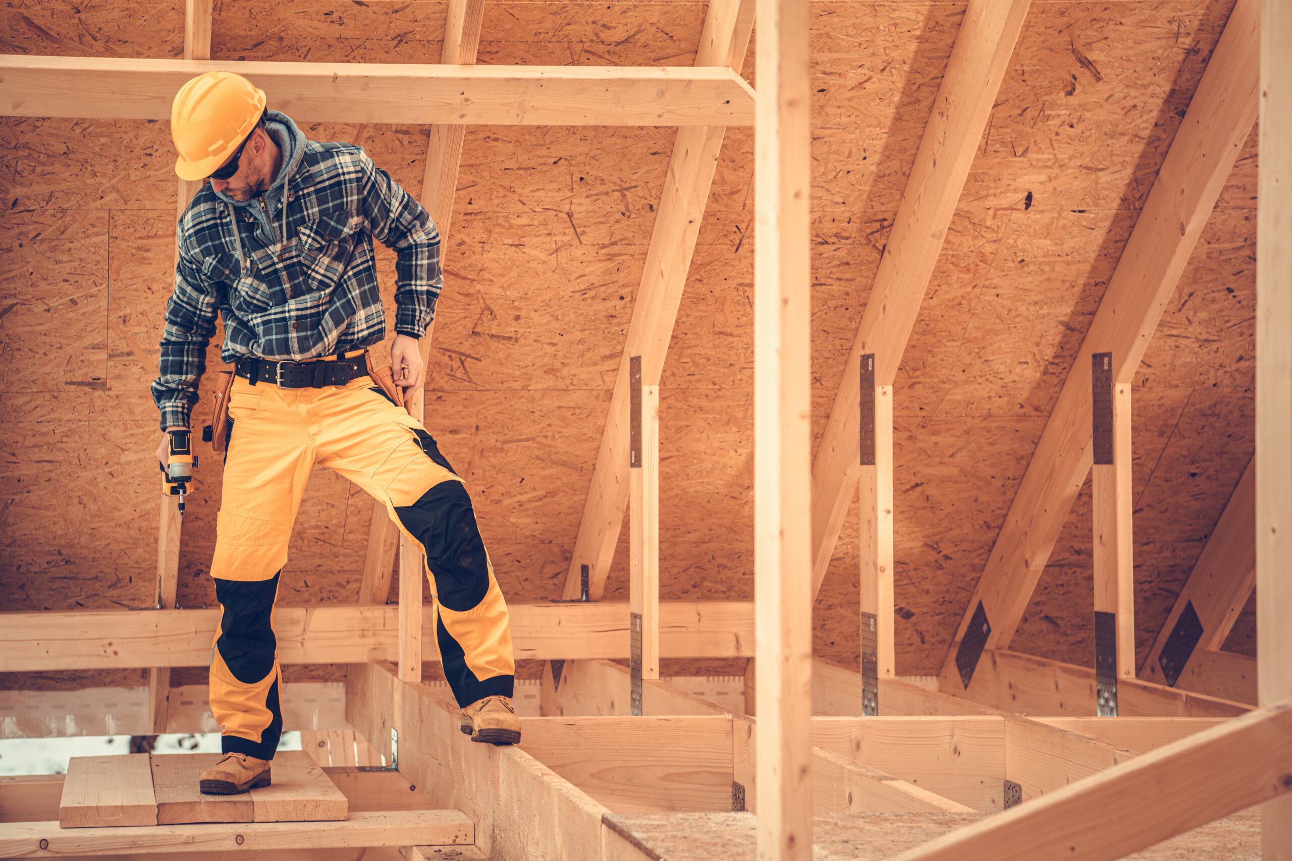 Construction Contractor Inside Newly Built Wooden House Skeleton